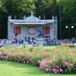 Zdjęcie przedstawia widok amfiteatru w świerklanieckim parku oraz publiczności uczestniczącej w koncerie w oddali
