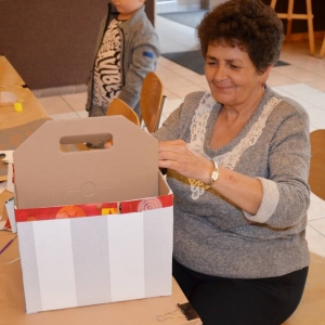 Zdjęcie przedstawia uczestniczkę wykonującą pudełko na przydasie
