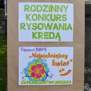 Zdjęcie przedstawia plakat informujący o konkursie rysowania kredą na alejce parkowej