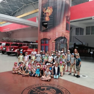 Zdjęcie przedstawia uczestników półkolonii podczas wizyty w Muzeum Straży Pożarnej