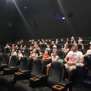 Zdjęcie przedstawia uczestników półkolonii podczas seansu w kinie