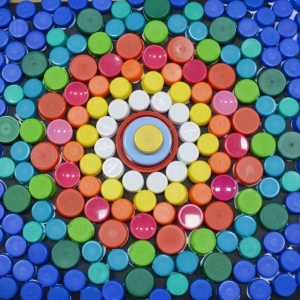 Zdjęcie przedstawia mandalę wykonaną z kolorowych zakrętek