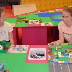 Zdjęcie przedstawia uczestników półkolonii IV turnusu w trakcie wycieczki na wystawę klocków LEGO podczas zwiedzania i wspólnej zabawy. 