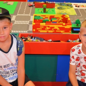 Zdjęcie przedstawia uczestników półkolonii IV turnusu w trakcie wycieczki na wystawę klocków LEGO podczas zwiedzania i wspólnej zabawy. 