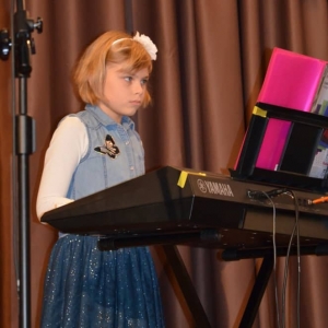 Zdjęcie przedstawia uczennicę zajęć keyboardowych podczas występu w Koncercie Noworocznym