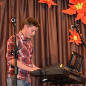 Zdjęcie przedstawia ucznia zajęć keyboardowych podczas występu w Koncercie Noworocznym