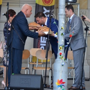 Zdjęcie przedstawia przekazanie przez Starostów chlebów dożynkowych Wójtowi Markowi Cylowi oraz Przewodniczącemu Rady Gminy Jarosławowi Wasążnikowi